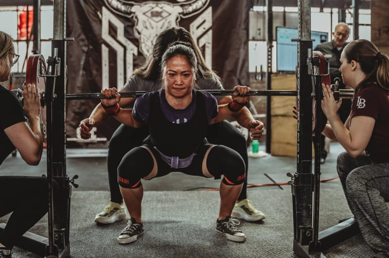 One-on-one coaching session with a squat at Per Aspera Strength