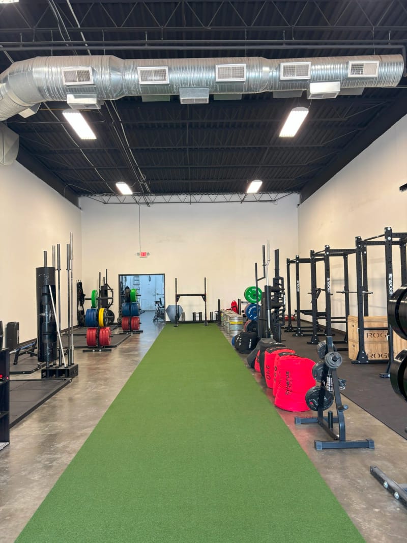 Inside Per Aspera Strength training gym showing squat racks and free weights