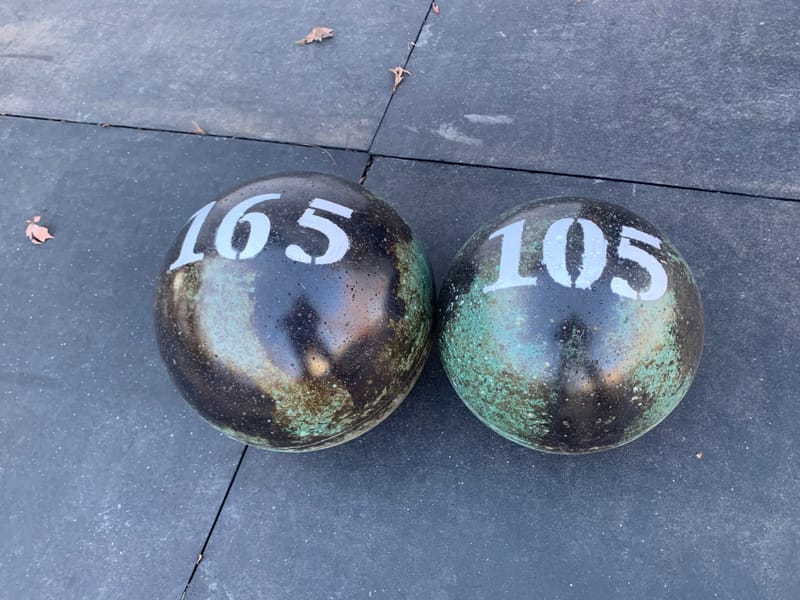 165 lb and 105 lb atlas stones in a green and black marbled finish, side by side