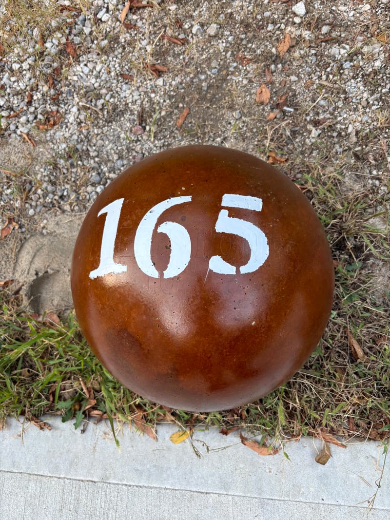 165 lb atlas stone in a red-brown finish with a stenciled number