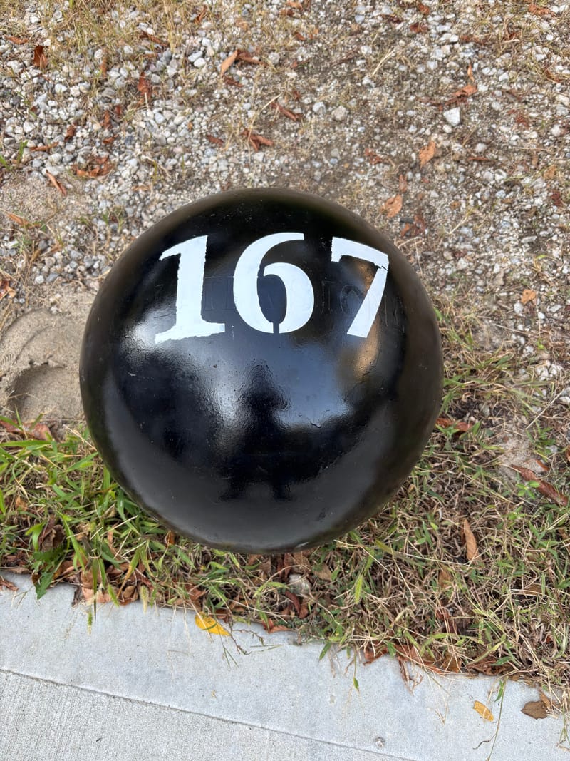 167 lb atlas stone in a black finish with a stenciled number