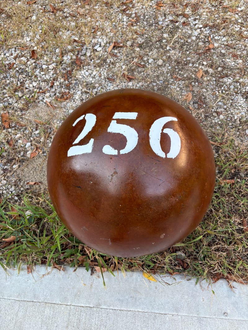256 lb atlas stone in a red-brown finish with a stenciled number