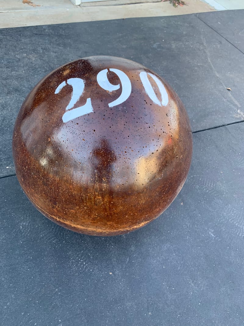 290 lb atlas stone in a glossy brown acid-stain finish with a stenciled number