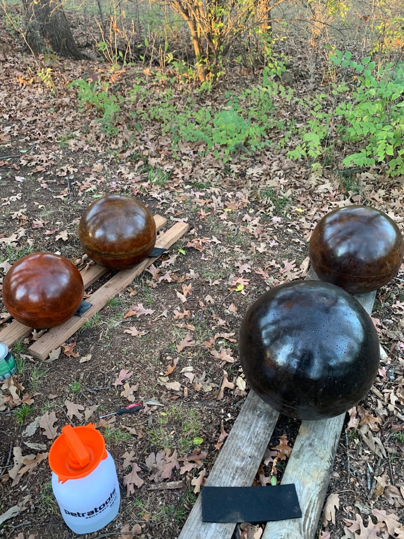 Four freshly sealed atlas stones in brown and black finishes drying outdoors